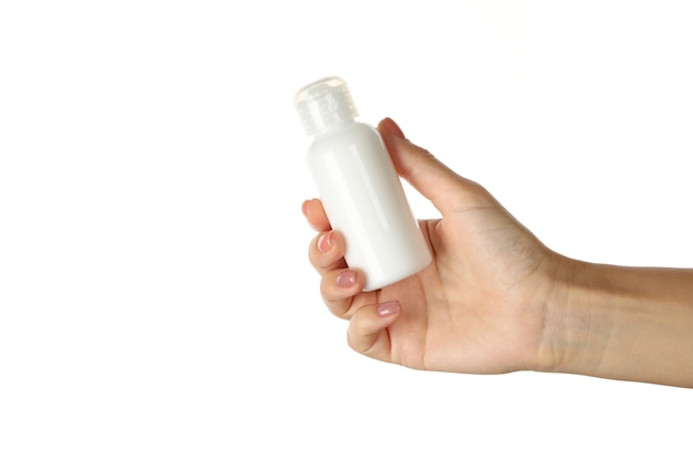 Female hand holding bottle of cosmetics