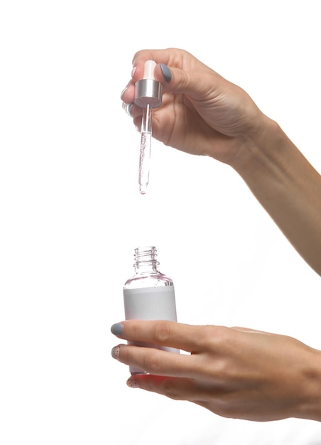 Female hand holding bottle serum with pipette isolated on white background