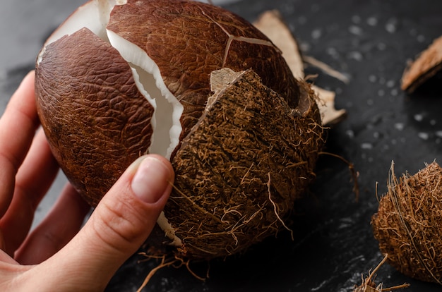 Female hand holding broken coconut