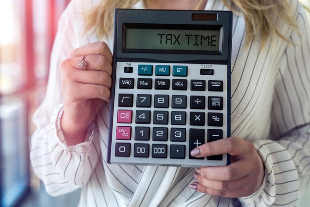 Female hand holding calculator in modern business center. finance concept