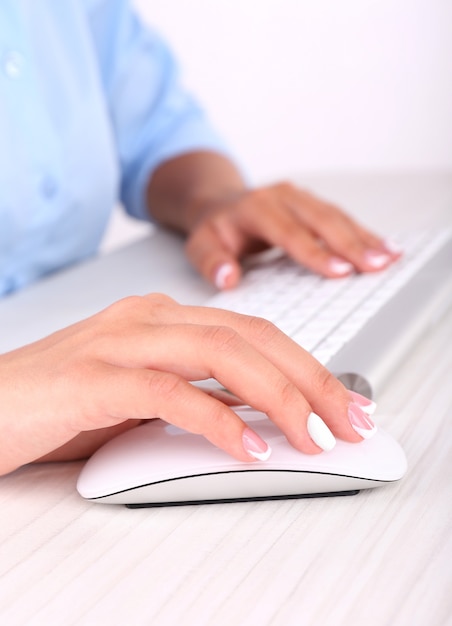 Female hand holding computer mouse, close-up,