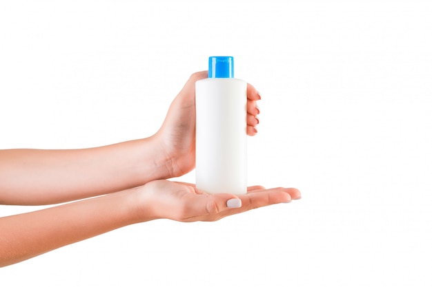 female hand holding cream bottle of lotion isolated. girl give cosmetic products