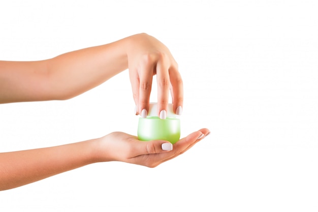 Female hand holding cream bottle of lotion isolated