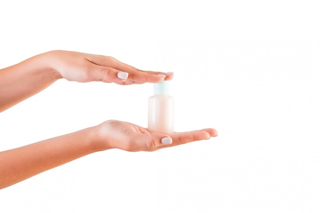 Female hand holding cream bottle of lotion isolated