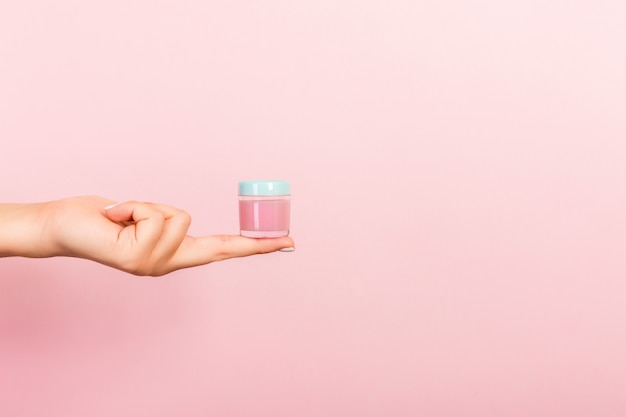 female hand holding cream bottle of lotion isolated
