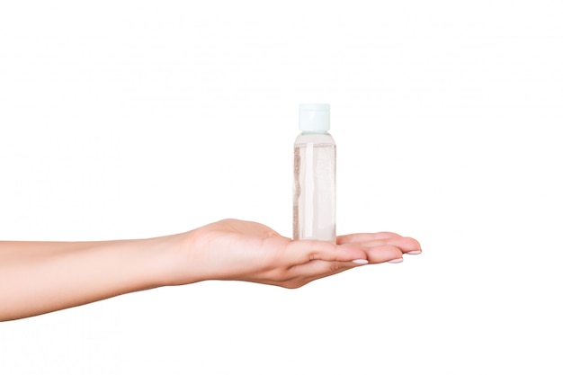 Female hand holding cream bottle of lotion