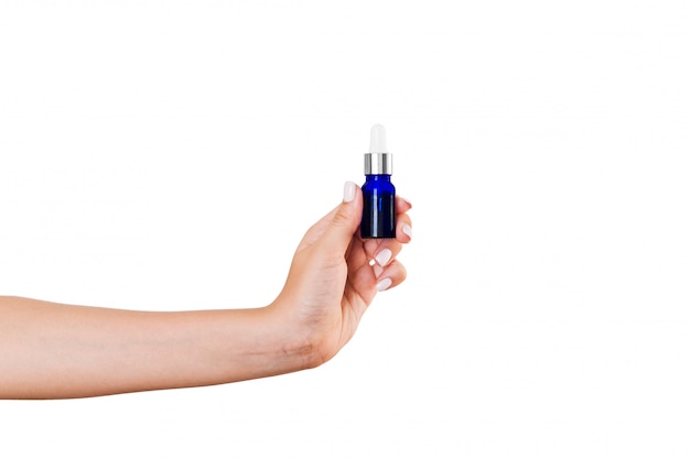 Female hand holding cream bottle of lotion