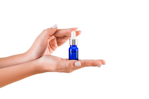 Female hand holding cream bottle of lotion