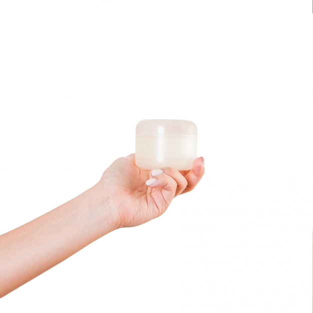 Female hand holding cream bottle