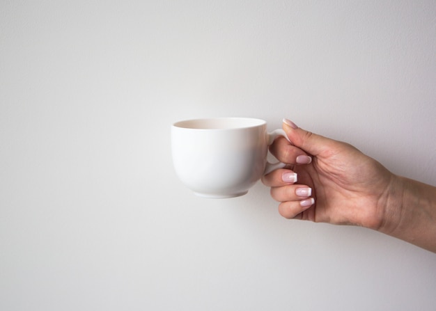 Photo female hand holding cup of coffee