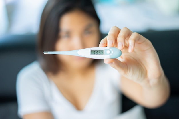 Female hand holding a digital thermometer