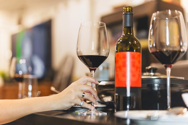 Female hand holding glasses of red wine