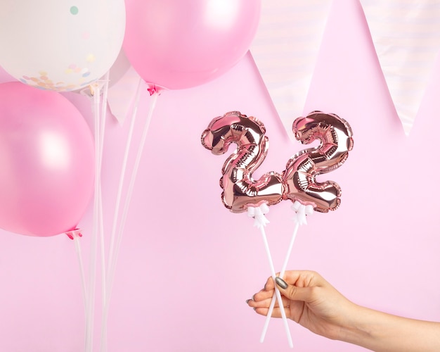 Female hand holding golden balloon in form of number