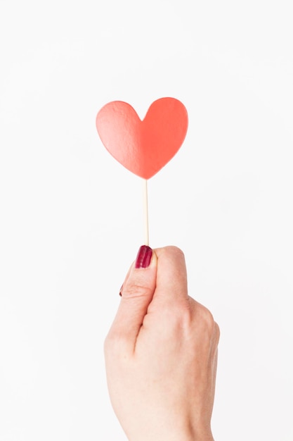 Female hand holding heart photo booth prop