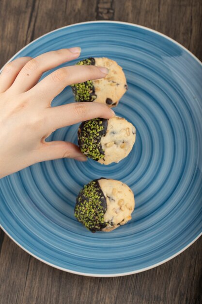 Female hand holding homemade shortbread cookie .