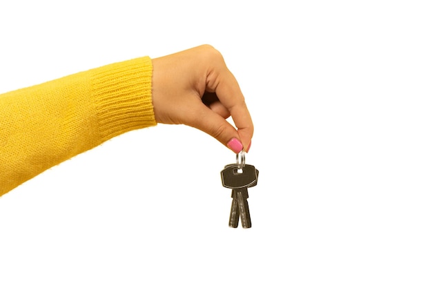 写真 白い背景で隔離を示唆する家の鍵を持っている女性の手