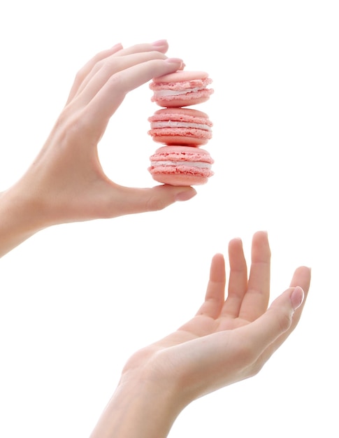 Female hand holding macaroons isolated on white