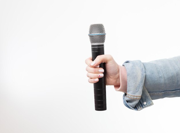 Female hand holding a microphone isolated on white background I have a voice