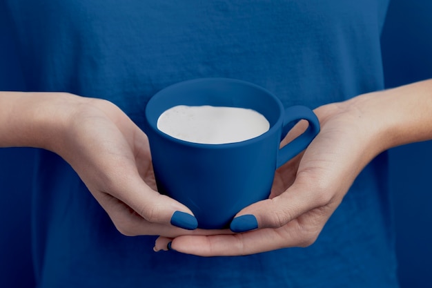 사진 올해의 색상에 우유 컵을 들고 여성 손