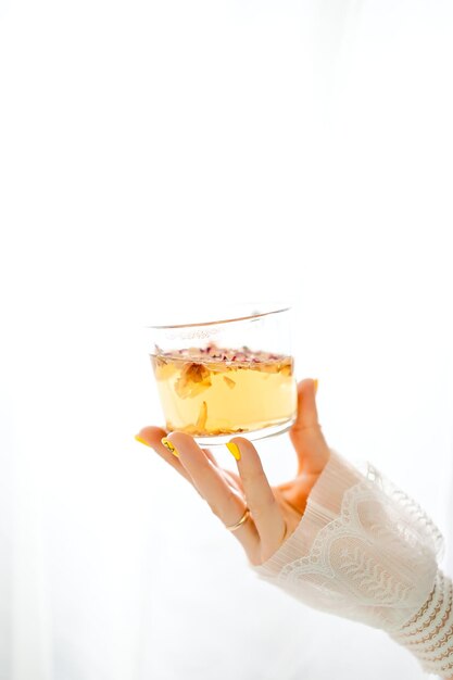 female hand holding a mug with hot tea on a white background