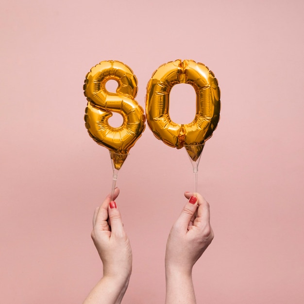 Female hand holding a number birthday anniversary celebration gold balloon