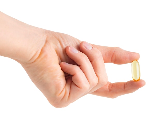 Female hand holding omega capsule isolated on white background with clipping path