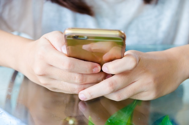 Photo female hand holding phone on glass table