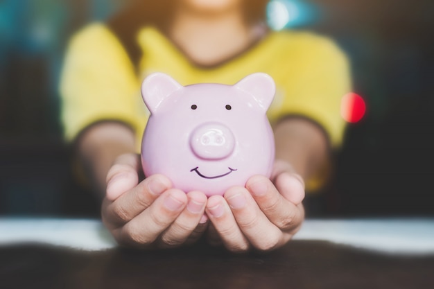 Female hand holding piggy bank