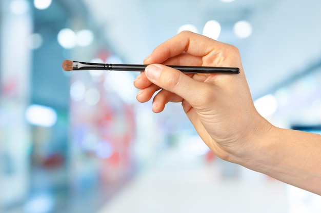 Female hand holding a professional makeup brush