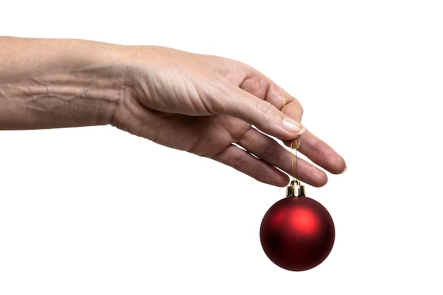 Female hand holding a red Christmas tree decoration, isolated