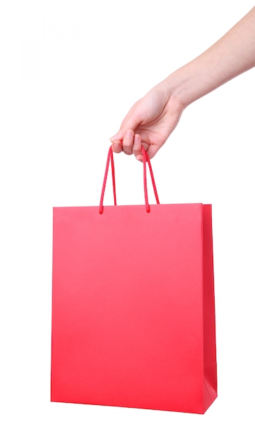 白で隔離され、赤いショッピングバッグを持っている女性の手
