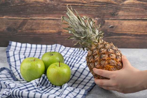 Female hand holding ripe pineapple