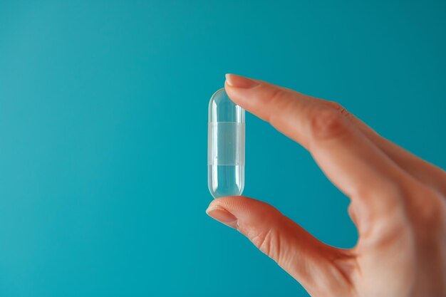 female hand holding a round white pill or vitamin young human hand holding vitamin omega3 pill in fingers