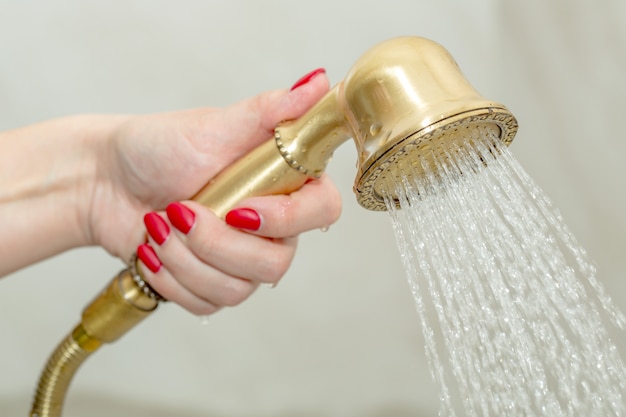 Photo female hand holding a shower head