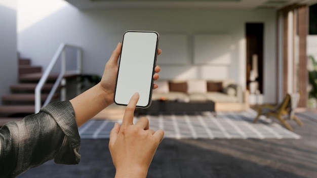 흐릿한 현대적인 거실 위에 스마트폰 모형을 들고 있는 여성 손