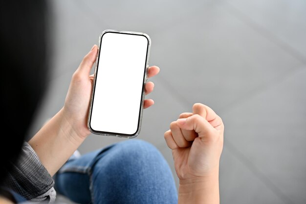 A female hand holding a smartphone mockup and showing clenched fist closeup image