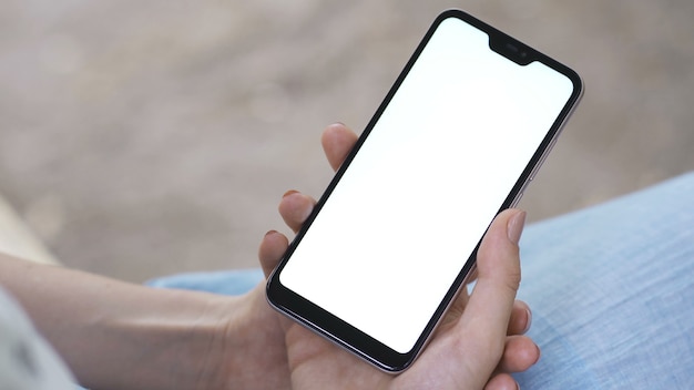 Female hand holding smartphone with white screen