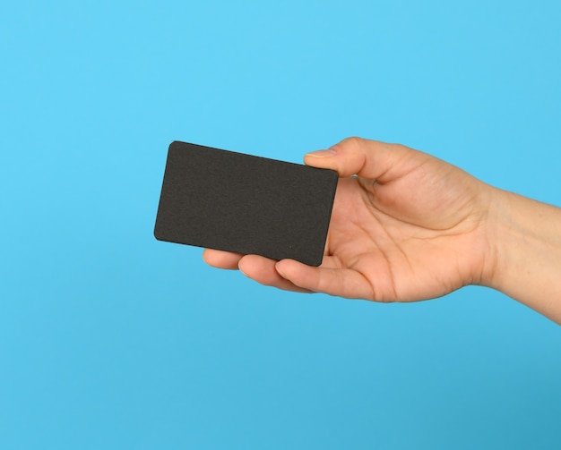 Female hand holding a stack of blank black business cards