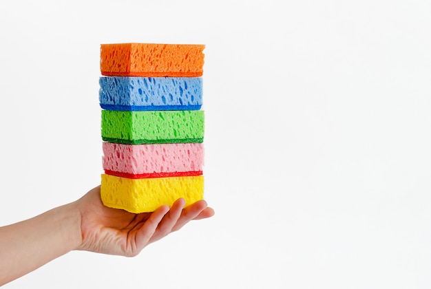 Female hand holding stack of sponges Cleaning goods concept. Copy space