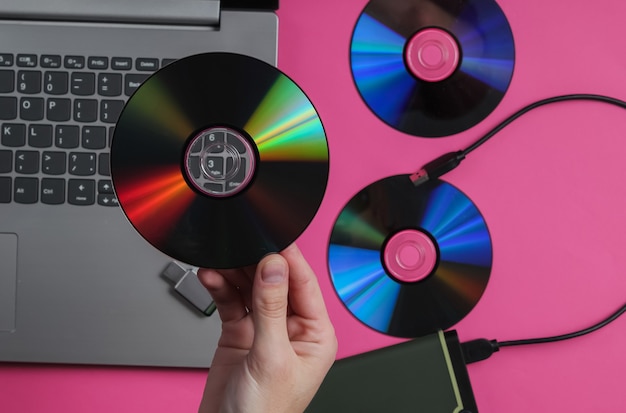 Female hand holds cd drives against the paper