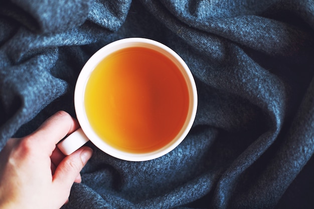 female hand holds a cup with tea