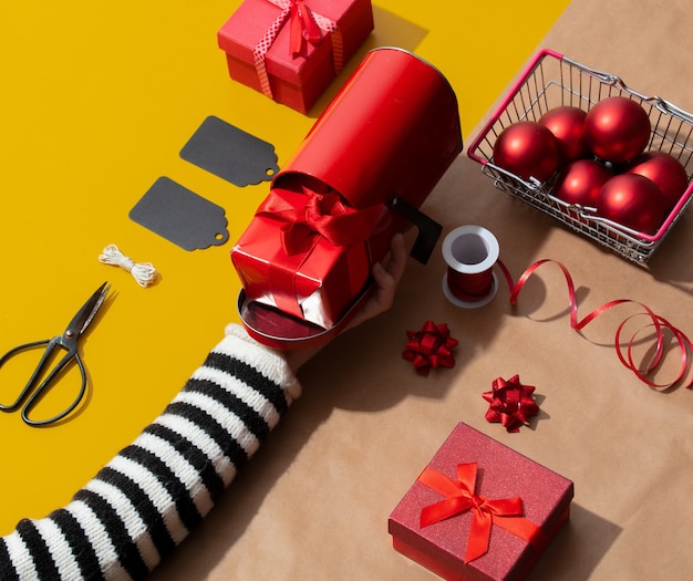 Female hand holds a mailbox near various Christmas objects