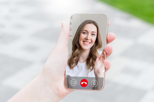 Female hand holds a mobile phone in hand and talking to her\
girlfriend on video chat video calls