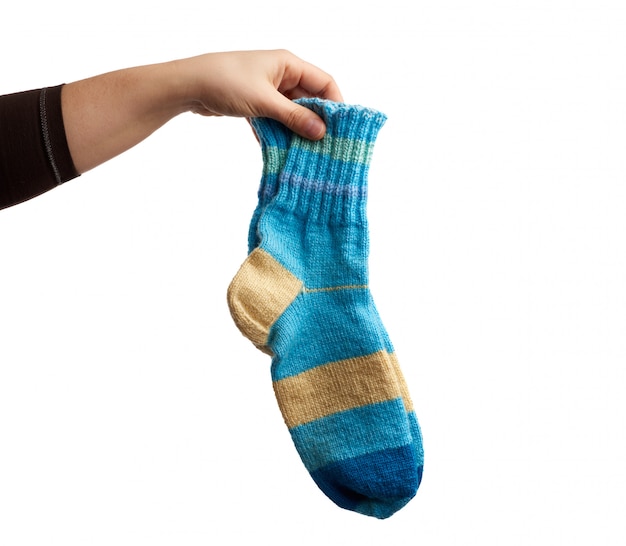 Female hand holds a pair of knitted woolen socks