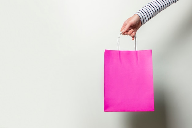 Female hand holds a shopping bag on a white. Concept shopping, discount, sale.