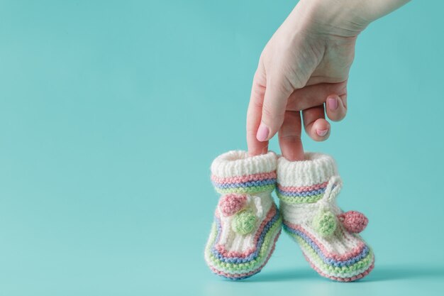 Female hand holds small baby shoes