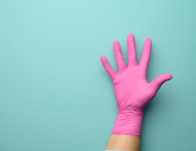 写真 青い背景にあるピンクのラテックス手袋の女性の手開いたコピースペース