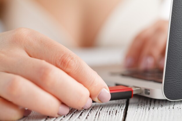 female hand inserting flash drive.