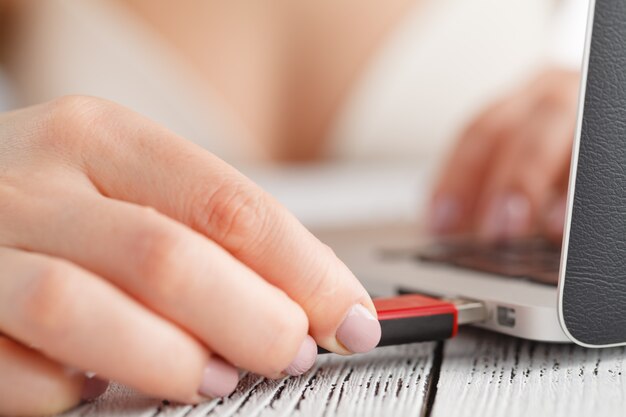 Female hand inserting flash drive.