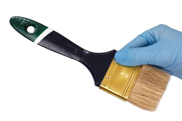 Photo female hand in a latex glove holding a house painter brush on a white isolated background. repair tool. building tool. close-up view.